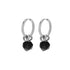 Symmetrical silver hoop earrings with black zircon stones on white background.