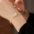 Gold pearl bracelet on a wrist with a blurred background