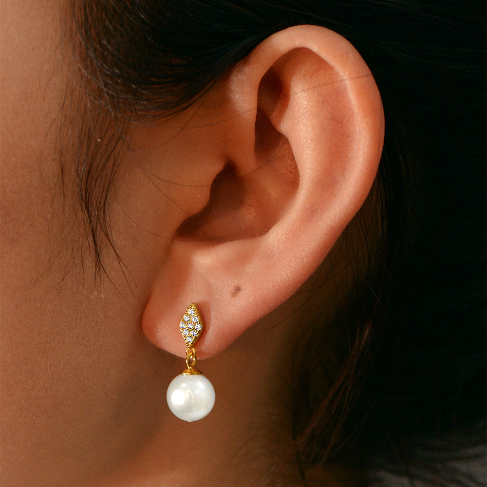 Gold pearl drop earring on ear, diamond-shaped stud, lightweight