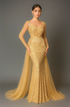 Woman wearing a gold sequin evening gown with a sheer overlay against a gray background