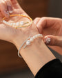 close-up of a hand wearing both the gold and silver pearl cuff bracelets together
