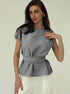 Gray sleeveless belted top styled with white pants, front view