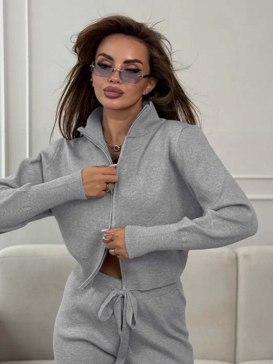 Woman wearing a gray 2 piece set sitting on a couch.