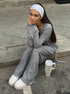 woman sitting on pavement wearing gray ribbed lounge set with white headband