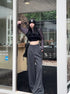 Gray high-waisted wide-leg trousers with subtle pleats and drawstring detail.