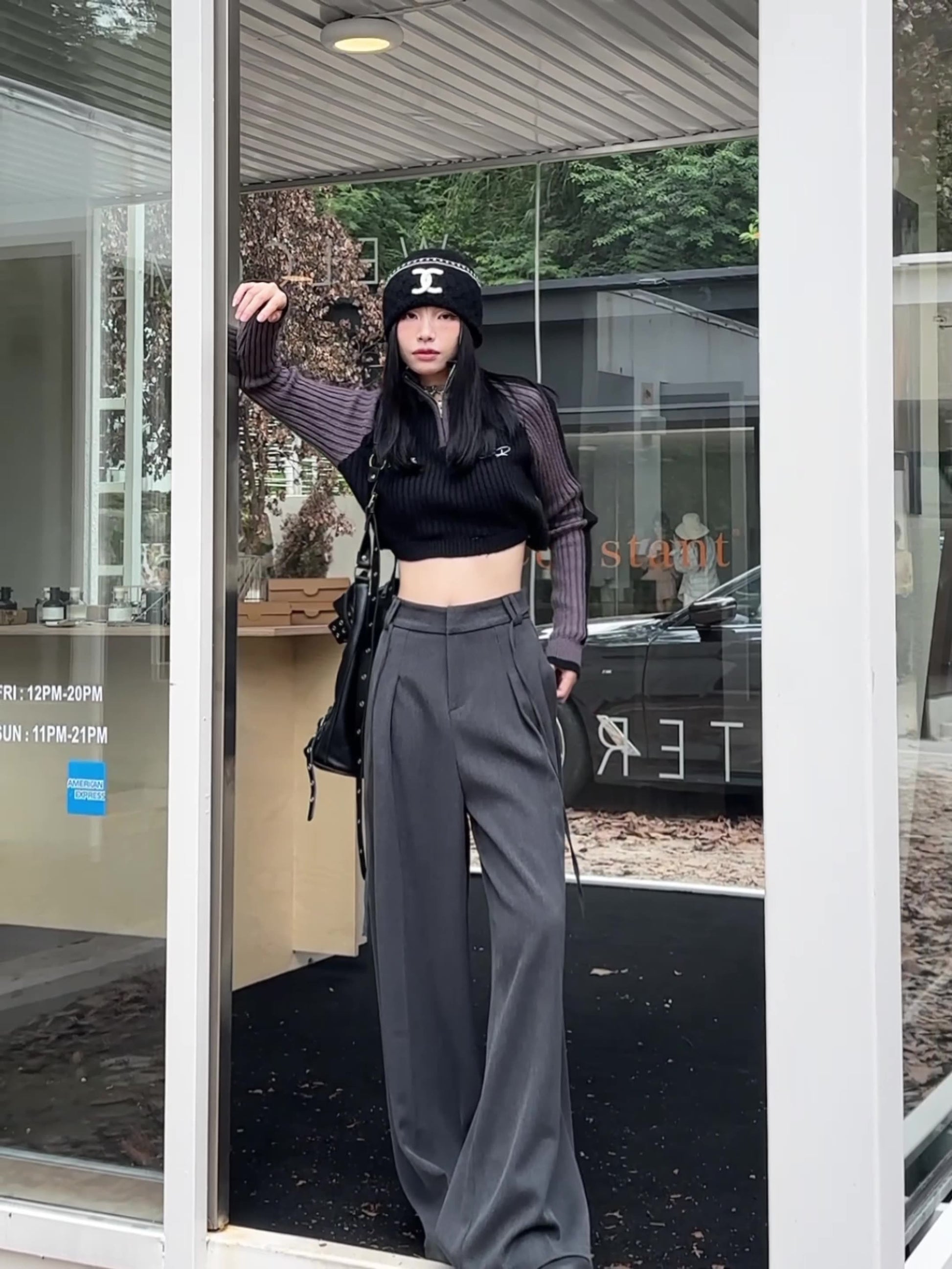 Gray high-waisted wide-leg trousers with subtle pleats and drawstring detail.