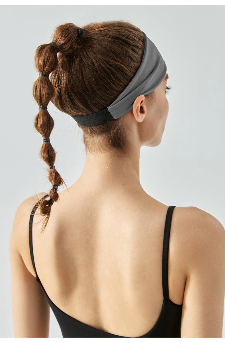 Back view of woman wearing gray workout headband with black strap.
