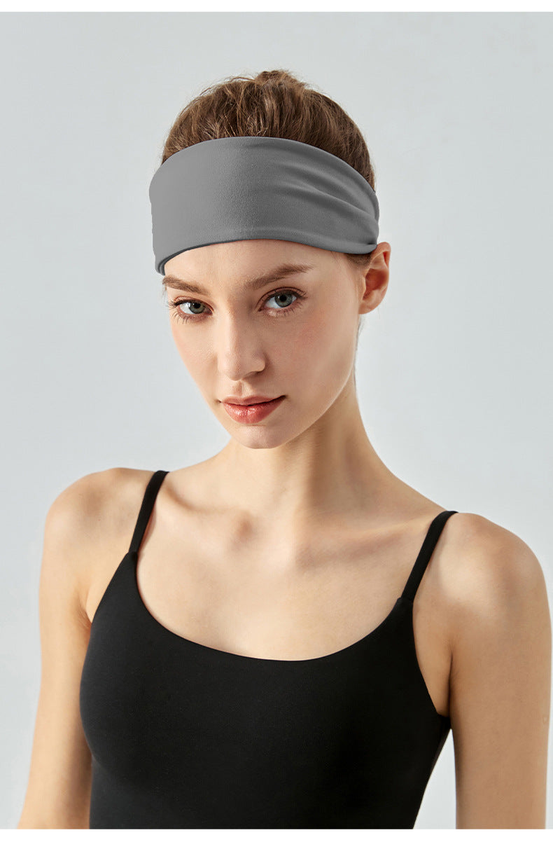 Front view of woman wearing gray workout headband.
