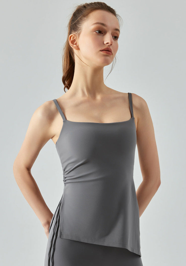 Portrait view of woman wearing gray cooling yoga tank top with square neckline.