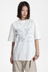 Medium shot of a model wearing a white relaxed crewneck t-shirt with hand-drawn sketch artwork.
