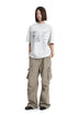 Full body view of a model standing in a loose fit heather grey short sleeve graphic t-shirt.