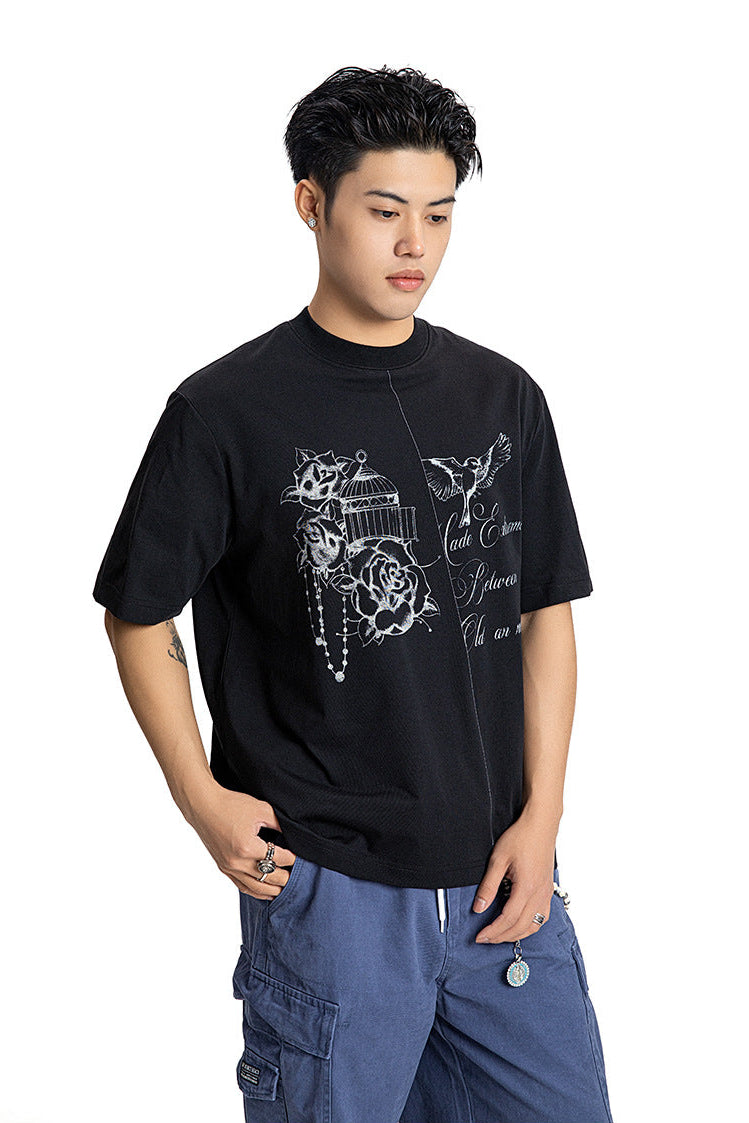 Front shot of a male model wearing a black graphic t-shirt with hand-drawn rose sketch artwork.