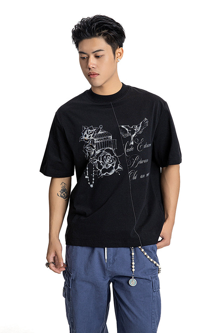 Medium shot of a male model in a black short sleeve crewneck tee with vintage script graphic.