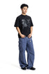 Full body shot of a male model wearing a black loose fit graphic crewneck tee with blue cargo pants.