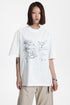 Front view of a model wearing a white cotton blend graphic t-shirt with delicate rose print.