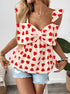 Model posing in heart print bow top with straw bag