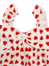 Close-up of bow and ruffle sleeve on heart print top