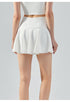 Back view of white high-waist tennis skirt with flared hem and fitted waistband.