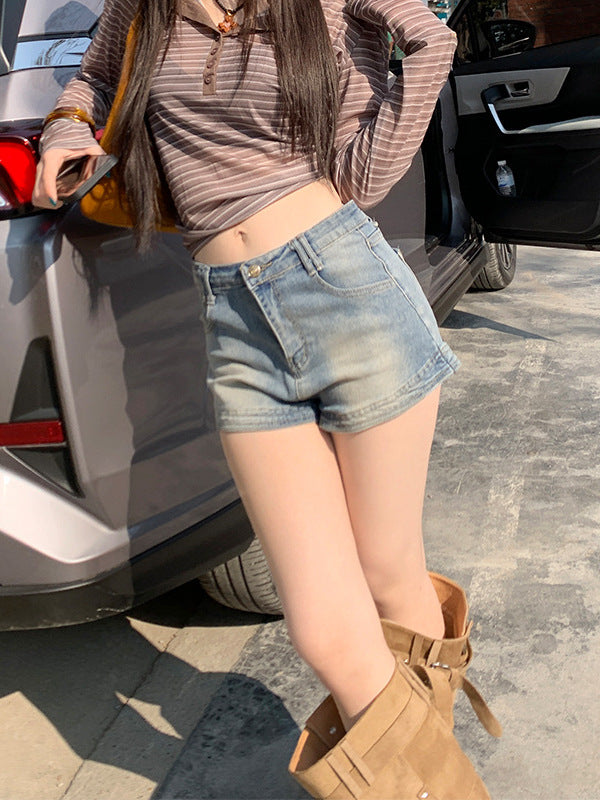 Woman posing in high waist faded denim shorts with brown striped top and suede boots by an open car door.