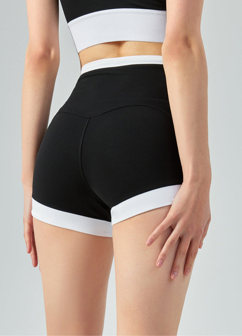 Back view of black high waisted workout shorts with white trim, highlighting contour seam
