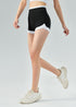 Model wearing high waisted black workout shorts with white trim, mid-stride.
