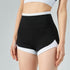 Model wears black high-waisted workout shorts with white trim.