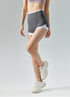 Model poses sideways in gray high-waisted athletic shorts.
