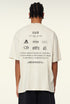 Back view of oversized graphic tee showing multiple printed logos and glitch text.