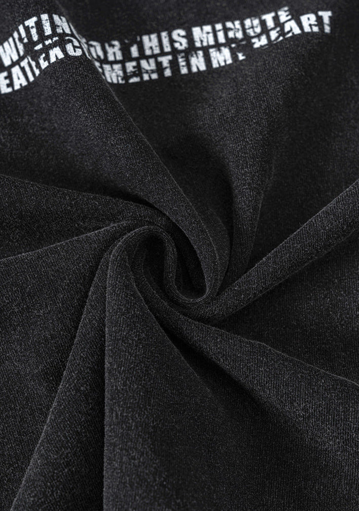 Black fabric twisted to show softness and stretch of cotton material.
