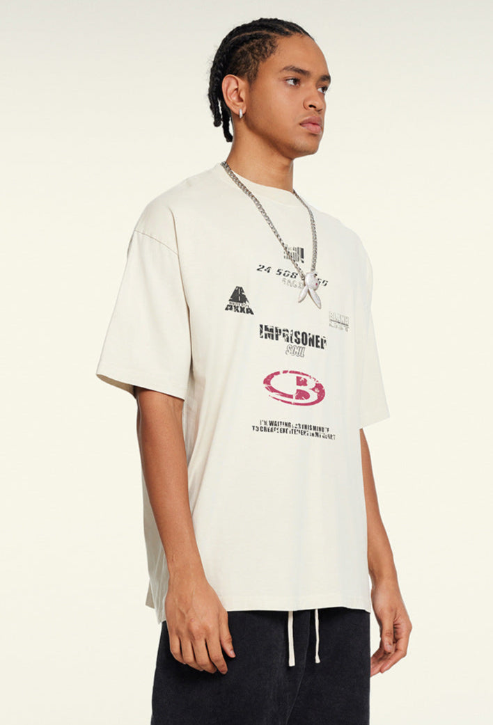 Man models cream oversized graphic tee with layered futuristic text designs.