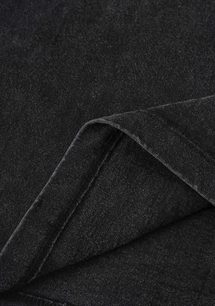 Detailed view of black washed cotton fabric with folded hem.