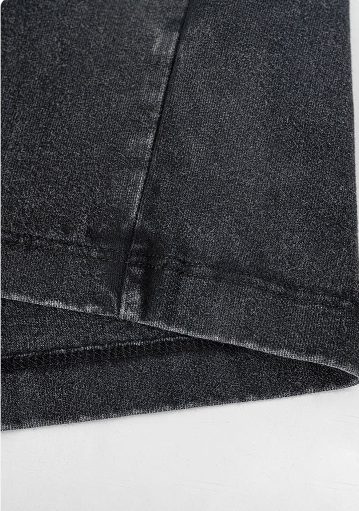 Zoomed-in look at double-stitched hem on washed black tee.