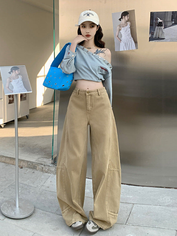 Front view of khaki curved hem wide-leg jeans paired with studded denim top.