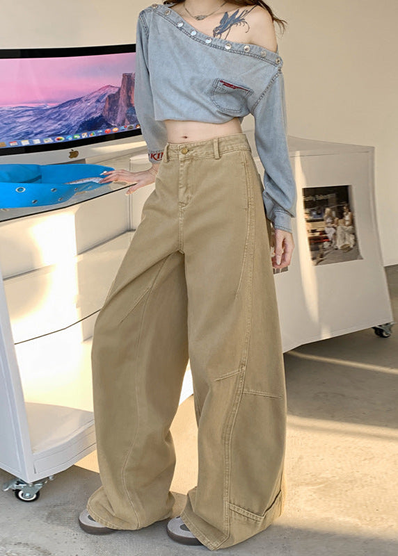 Side angle of khaki wide-leg jeans styled with off-shoulder denim top indoors.