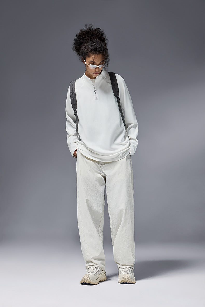 Women wearing khaki half zip long sleeve t shirt styled with beige pants