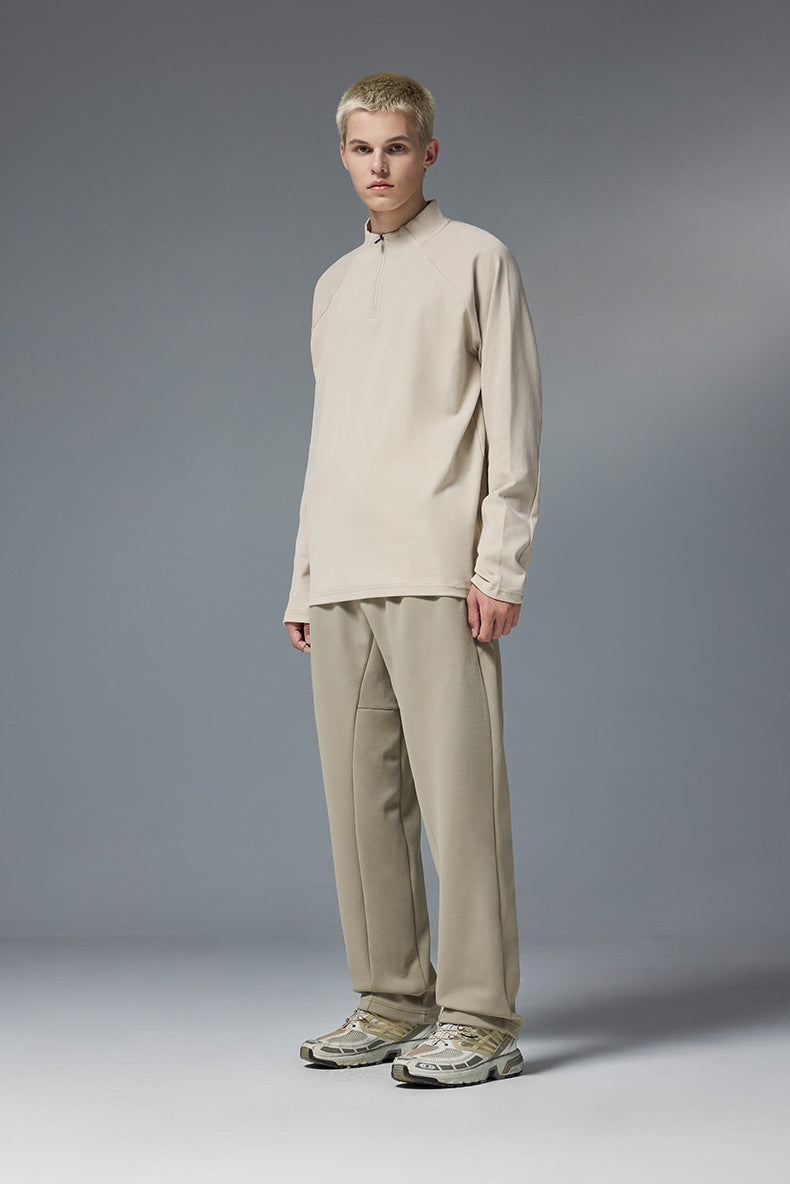 Man wearing khaki half zip long sleeve t shirt styled with beige pants