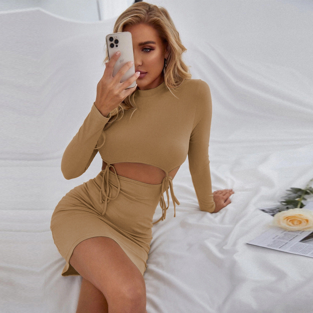 Khaki long sleeve mini dress with waist cut-out and fitted skirt shown in seated angled pose.