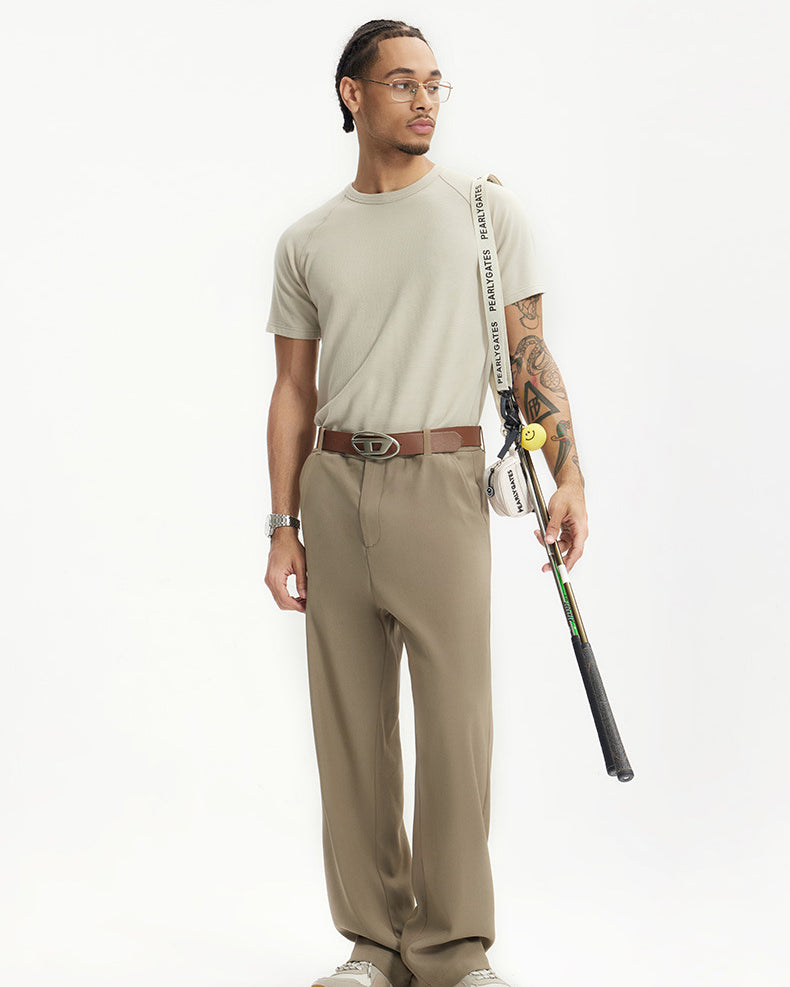 Man wearing khaki mens dress pants with white sneakers and brown belt