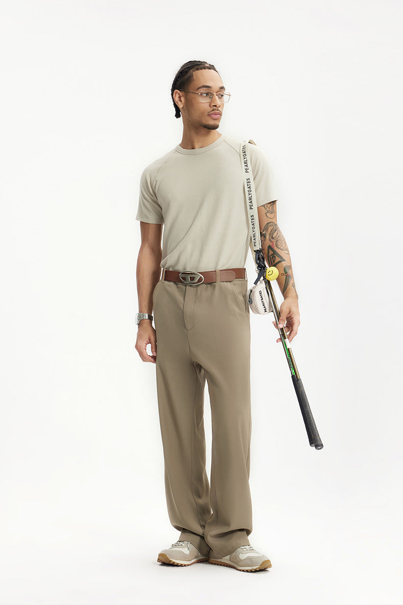 Man wearing khaki mens dress pants with white sneakers and brown belt