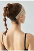 Back view of woman wearing khaki headband with black elastic band.
