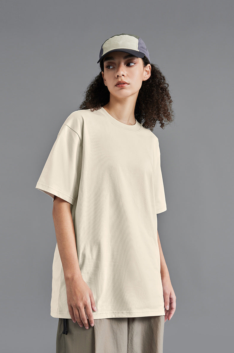 Female model in khaki oversized tee with white cap, studio backdrop