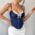 Navy blue corset with white lace bust and satin bow, paired with white mini skirt.
