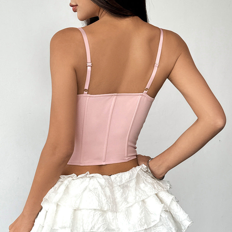 Back view of pink corset with adjustable straps, paired with ruffle mini skirt.