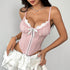 Pink lace corset with bow detail, styled with ruffled white mini skirt.