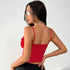 Woman wearing a red lace corset top and black skirt, shown from the back.