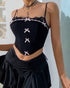 Close-up of a black corset with lace trim and pink bow accents, styled with layered necklaces and a black skirt.