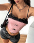 Woman in a pink corset top with black lace trim and black bows, paired with black denim shorts and a heart necklace.