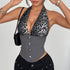 Woman posing in a gray leopard print halter corset top with black shorts and a black purse.