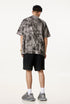 Model wearing grey Liberalism tee from the back, showing full rear abstract design.