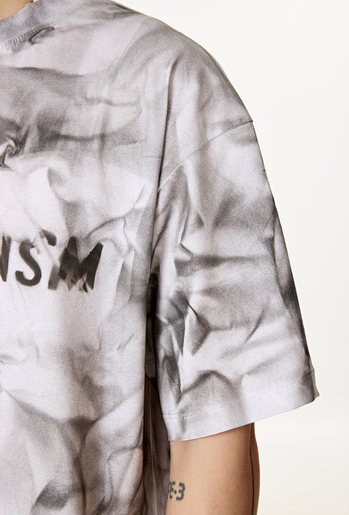 Close-up of white tee sleeve and partial “Liberalism” print.